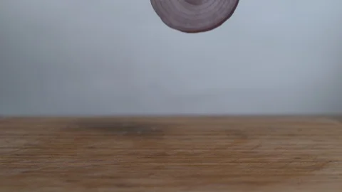Slice onion falls on the chopping board in slow motion Stock Footage 100008813