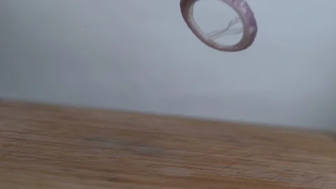 Slice onion falls on the chopping board in slow motion Stock Footage 100008865
