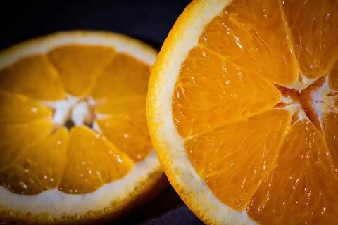 Slice of orange on black, close up Stock Photos