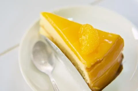 Slice orange cake in white ceramic plate Stock Photos