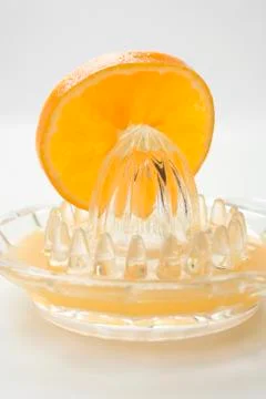 Slice of orange on citrus squeezer Stock Photos