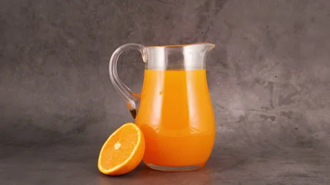 Slice of orange fall in orange juice and splashing Stock Footage 130880733