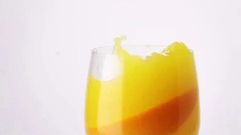 Slice of Orange Falling into a Glass of Orange Juice. Stock Footage 73039959