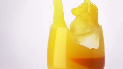 Slice of Orange Falling into a Glass of Orange Juice Stock Footage 144844904