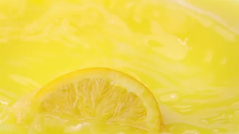 Slice of Orange Falling into Orange Juice. Stock Footage 72965646