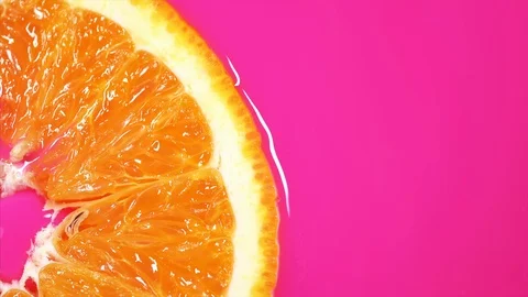 Slice orange floats in pink fresh juice. Juicy piece of orange Stock Footage 117371402