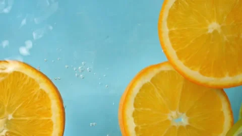 A slice of orange gracefully plunges into the water, causing delightful splash Stock Footage 269995314