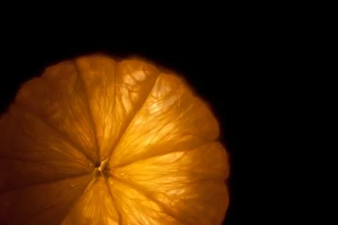 A slice of orange isolated on a black background Stock Photos