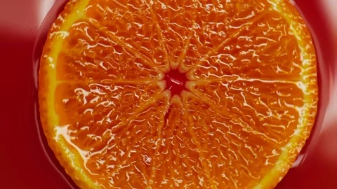 Slice of orange rotating close-up on red background 動画素材 125885362