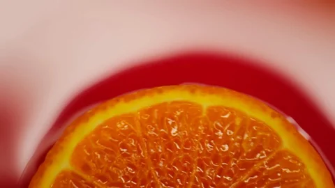 Slice of orange rotating close-up on red background Stock Footage 125885379