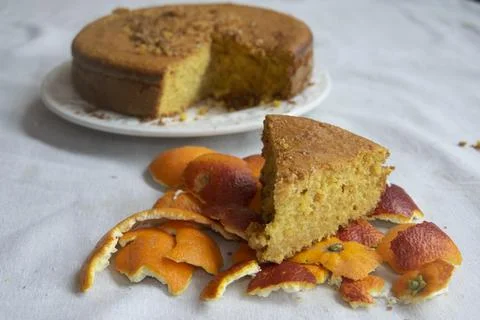 Slice of orange sponge cake on citrus peels Stock Photos