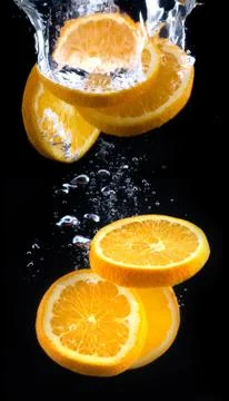 Slice of orange in the water with bubbles Stock Photos