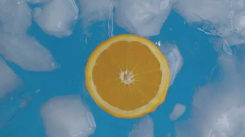 Slice of orange in water with ice Stock Footage 160984076