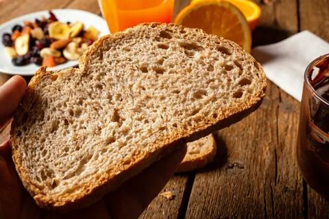 Slice of organic wholemeal bread on rustic table. Stock Photos