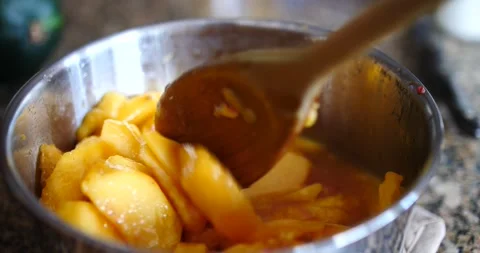 Slice peaches being stirred in silver pan making peach cobbler Stock Footage 207336924