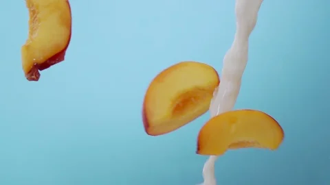 Slice of Peaches Splashing into Milk Stock Footage 108308438