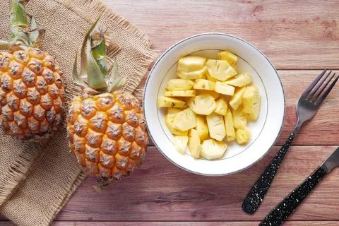 Slice of pineapple in bowl on table Stock Photos