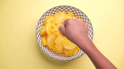 Slice of pineapple in bowl on yellow background Stock Footage 188802936