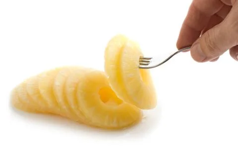 Slice of pineapple on a fork Stock Photos