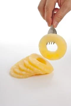 Slice of pineapple on a fork Stock Photos