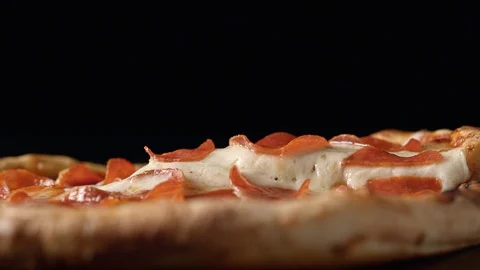 A slice of pizza being picked up out of a whole pizza. Slow Motion. Stock Footage 121496103