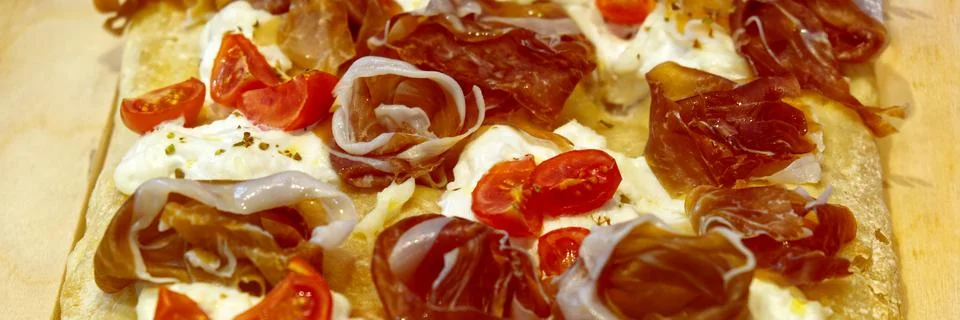 A slice of pizza with cherry tomatoes and speck Stock Photos