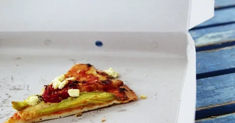 Slice of pizza with missing bite in pizza box 스톡 동영상 77690592