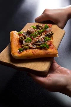 Slice of pizza. Serving pizza on kitchen board. Stock Photos