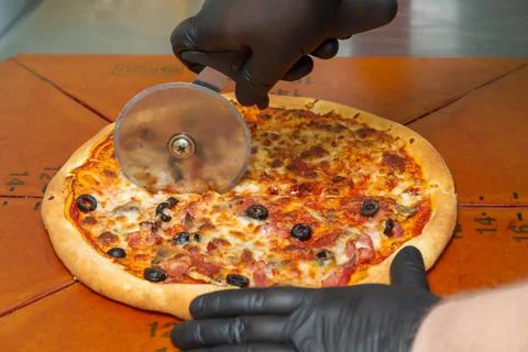 Slice the pizza with the wheel. Stock Photos