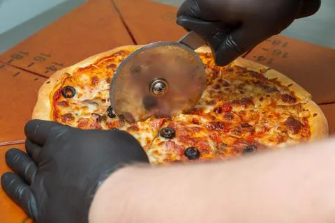 Slice the pizza with the wheel. Stock Photos