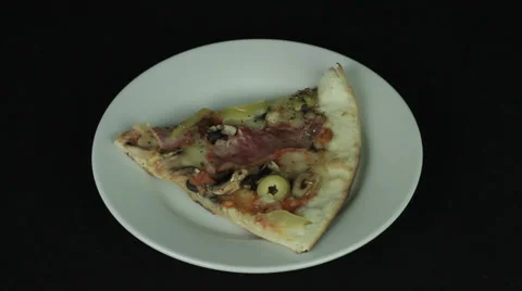 Slice of pizza in a white plate on a black background revolves Stock Footage 35348044