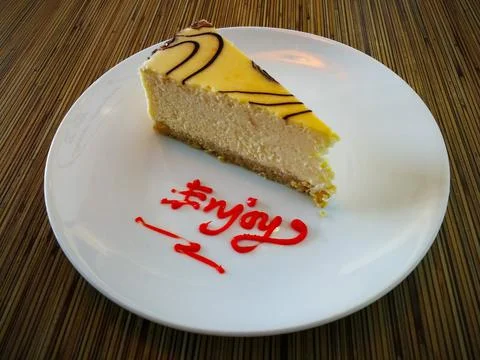 Slice of plain Marble Cheesecake and enjoy text on white plate Stock Photos
