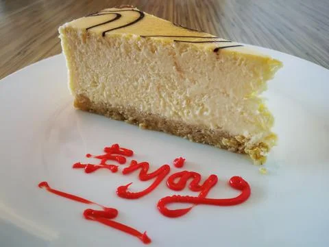 Slice of plain Marble Cheesecake and enjoy text on white plate Stock Photos
