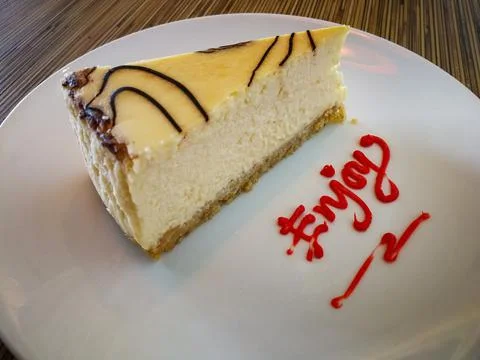 Slice of plain Marble Cheesecake and enjoy text on white plate Stock Photos