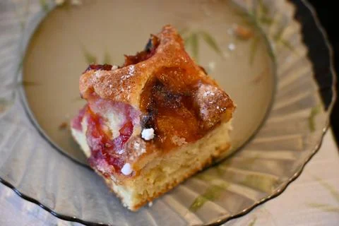 Slice of plum sponge cake on a glass plate Stock Photos