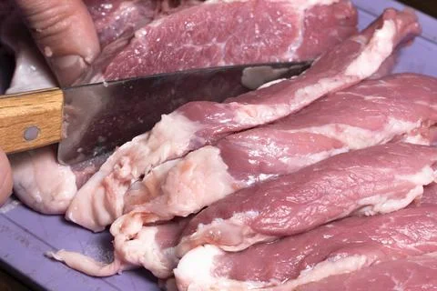 Slice the pork or beef with a knife on the table in close-up.Preparation of m Stock Photos