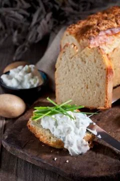 Slice of potato bread spread with herbed curd cheese Stock Photos