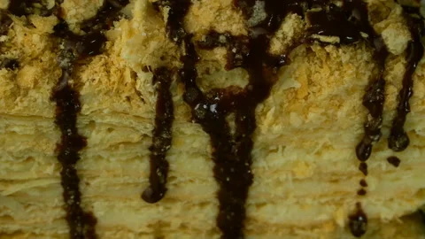 Slice of puff appetizing Napoleon cake is poured on top with chocolate fondant. Vídeo Stock 131848010