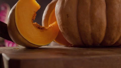 Slice of Pumpkin falling on a wood table Stock Footage 135008578