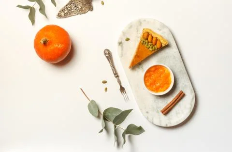 A slice of pumpkin pie on a marble stand with cinnamon and pumpkin jam. On a Stock Photos