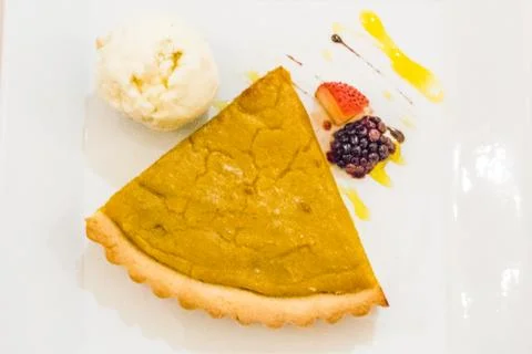 A slice of pumpkin pie served with vanilla ice cream and raspberry and strawb Foto stock