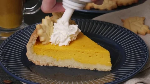 Slice of pumpkin pie with whipped cream on a dark blue plate Stock Footage 138936124