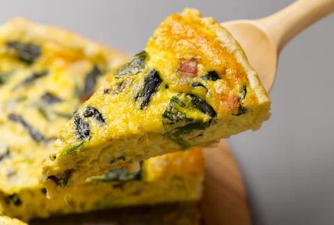 A slice of quiche with bacon and spinach Foto stock