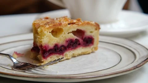 Slice of Raspberry and Rhubarb Frangipane Tart featuring a moist almond sponge. Stock Footage 337127170