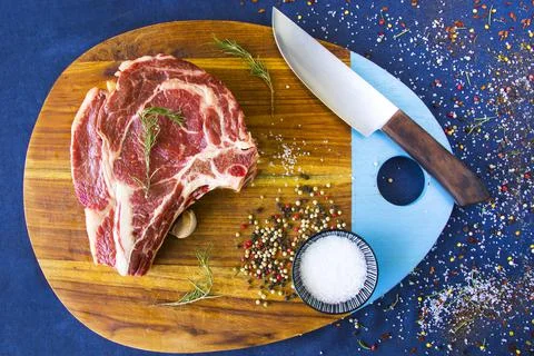 Slice of raw beef steak on a kitchen table with spices and herbs Stock Photos