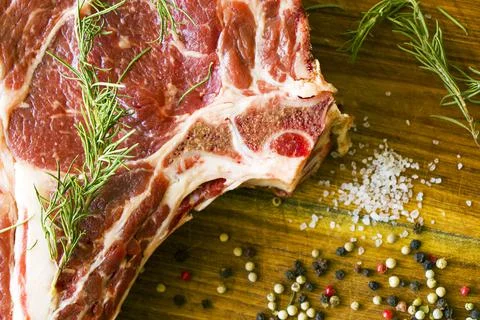Slice of raw beef steak on a kitchen table with spices and herbs Stock Photos