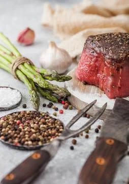 Slice of Raw Beef Topside Joint with Salt and Pepper on round chopping board Stock Photos