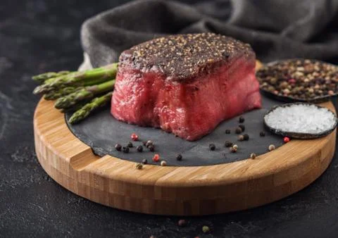 Slice of Raw Beef Topside Joint with Salt and Pepper on stone chopping board Stock-Fotos