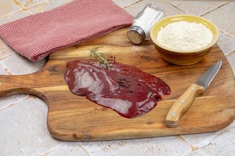 Slice of raw liver on a cutting board Stock Photos