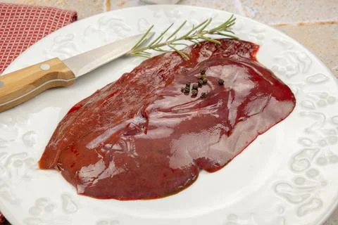 Slice of raw liver in a plate Stock Photos